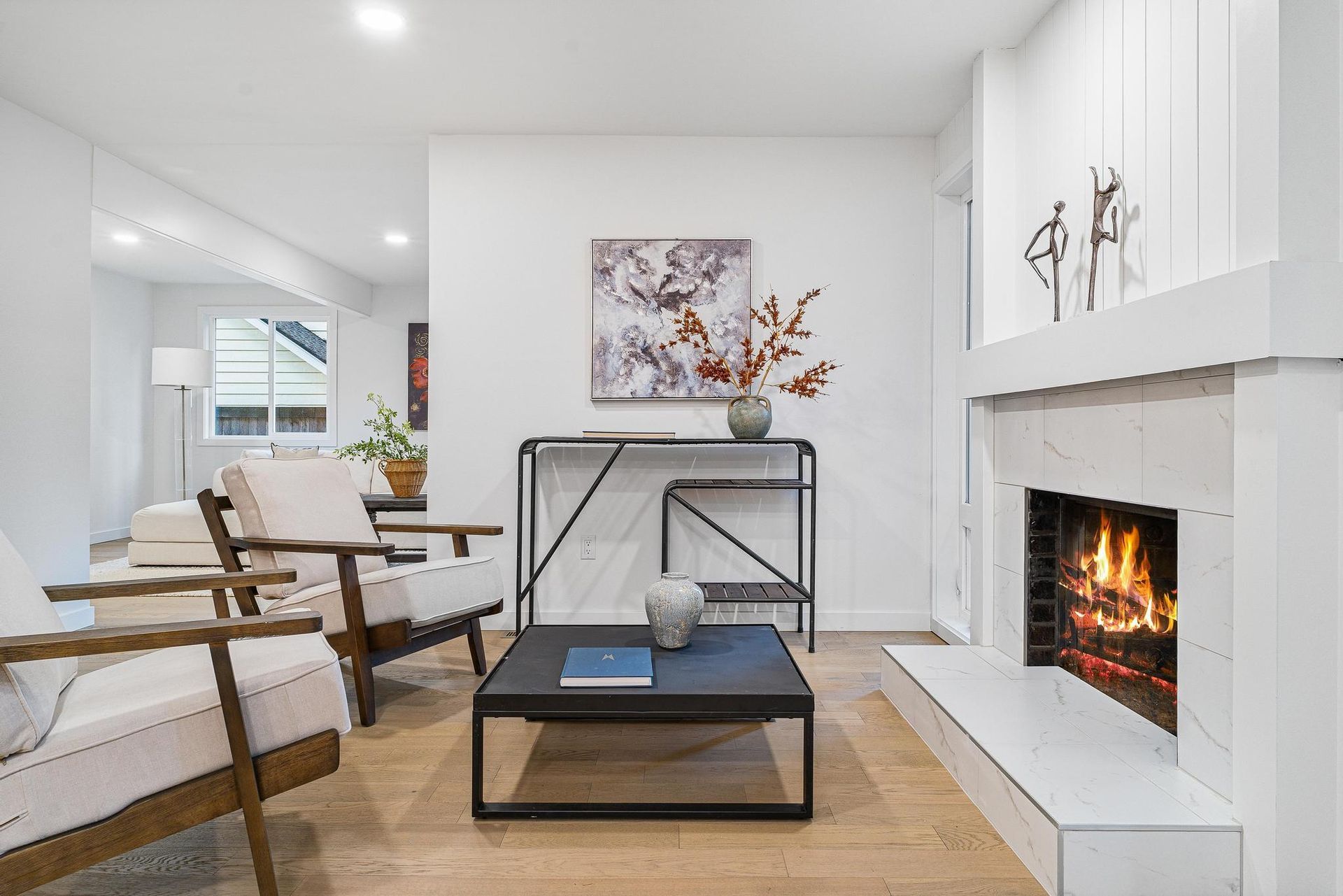 A living room with a fireplace , chairs and a coffee table.
