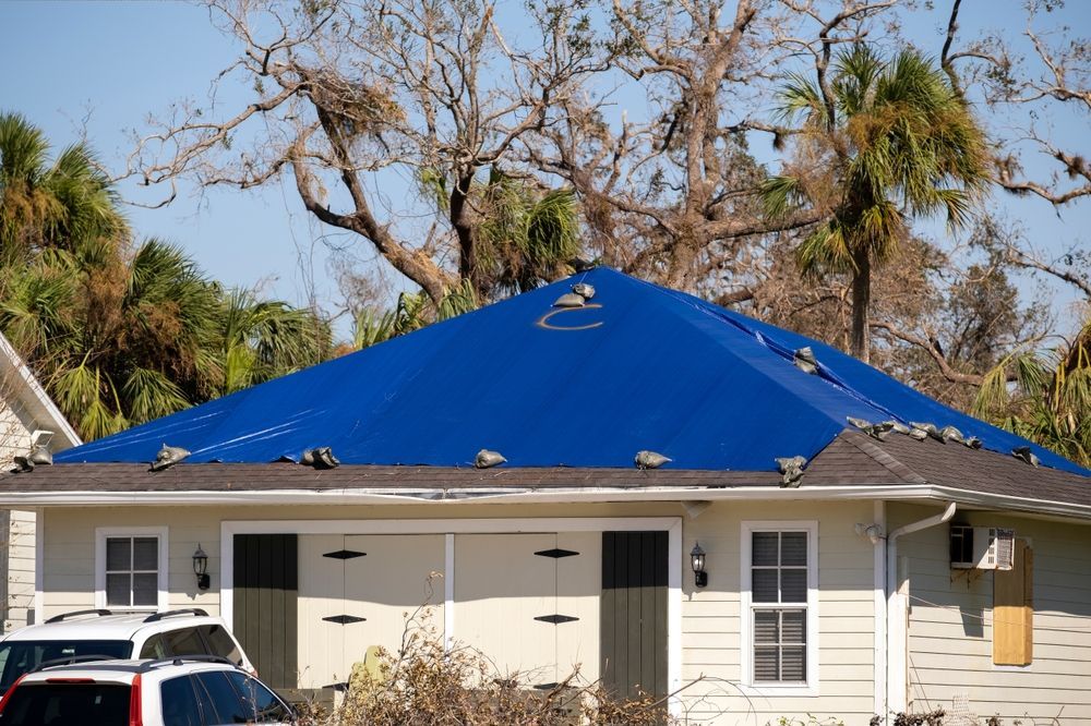 A house with a blue tarp on the roof.
