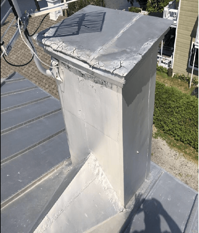 Une cheminée est posée au sommet d'un toit métallique.