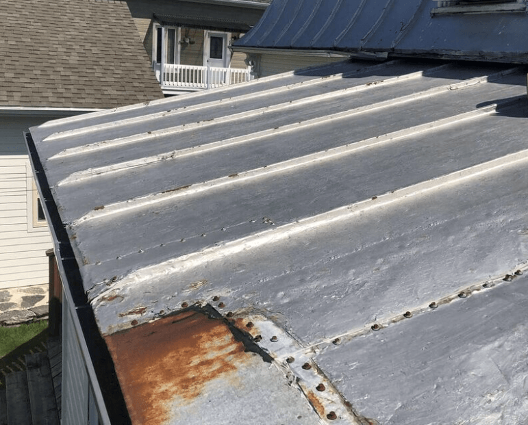 Un gros plan d'un toit en métal rouillé sur une maison.