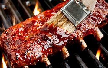 Rib steak on a BBQ painted with sauce