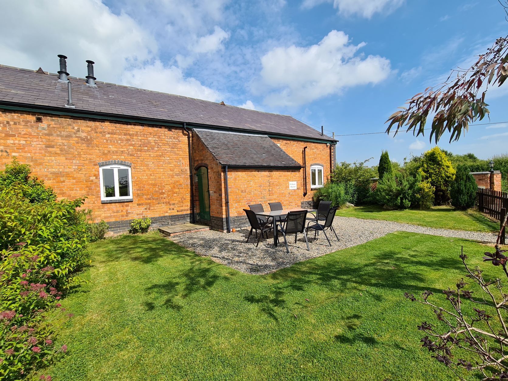 Brick cottage with garden and patio on a sunny day