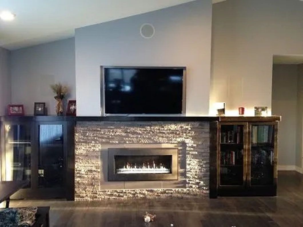 A modern living room with a fireplace, TV, and built-in cabinets in neutral tones.