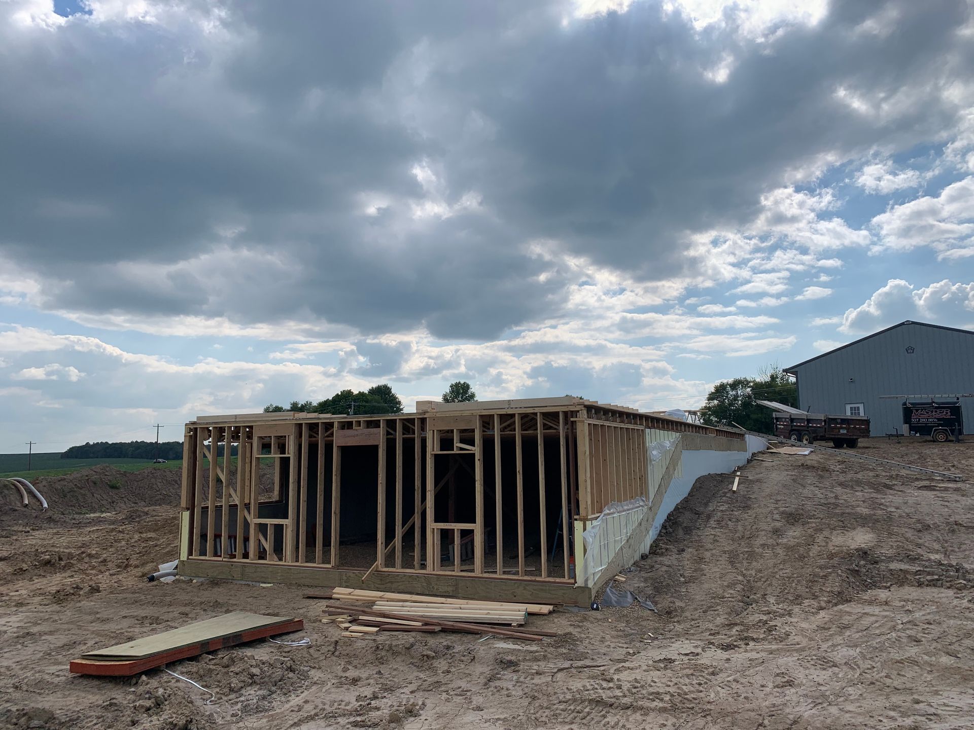 Wooden frame of a building under construction; exterior view on a cloudy day.