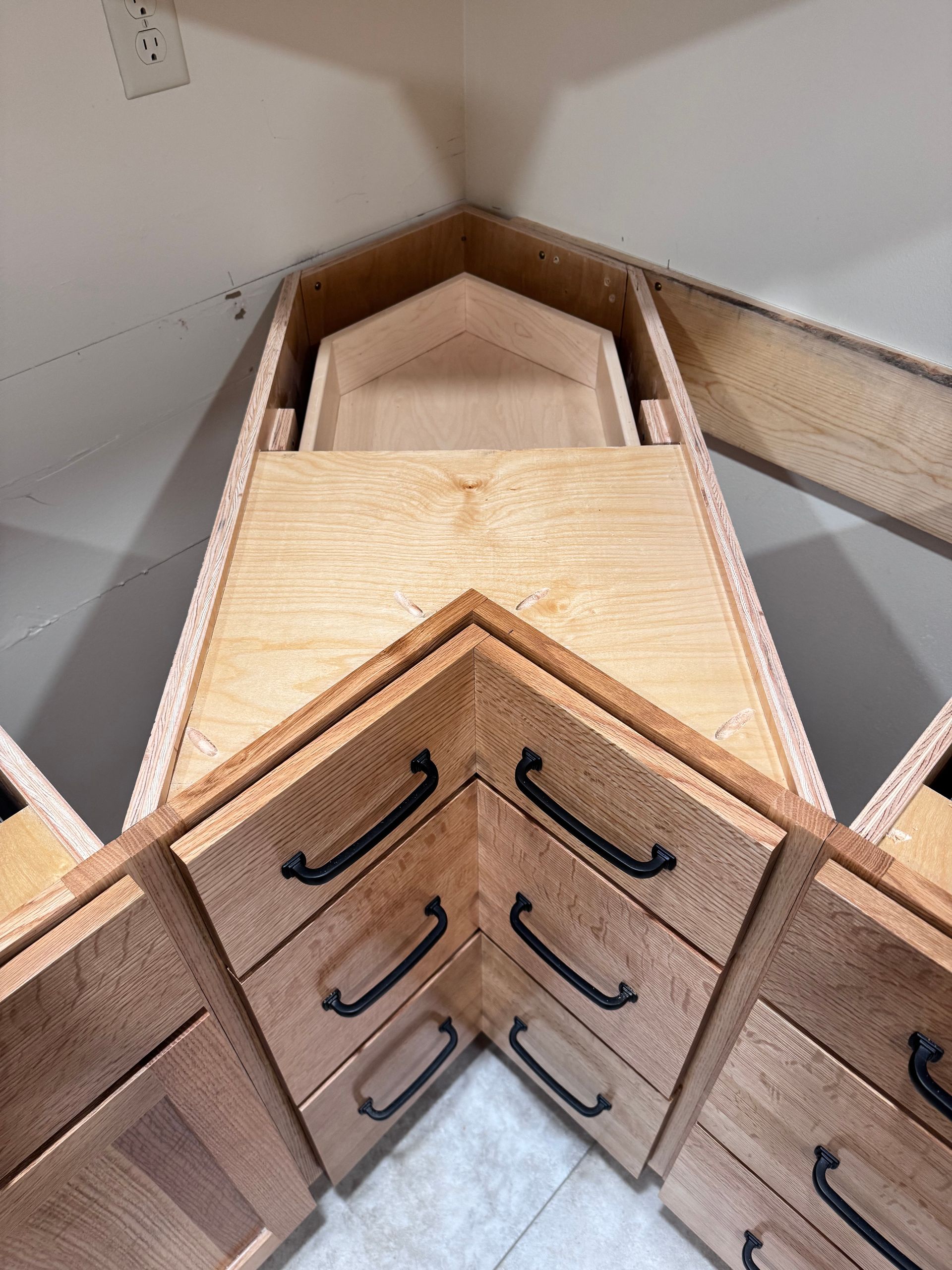 Corner kitchen cabinet setup with drawers and pull-out shelves, wood tones.