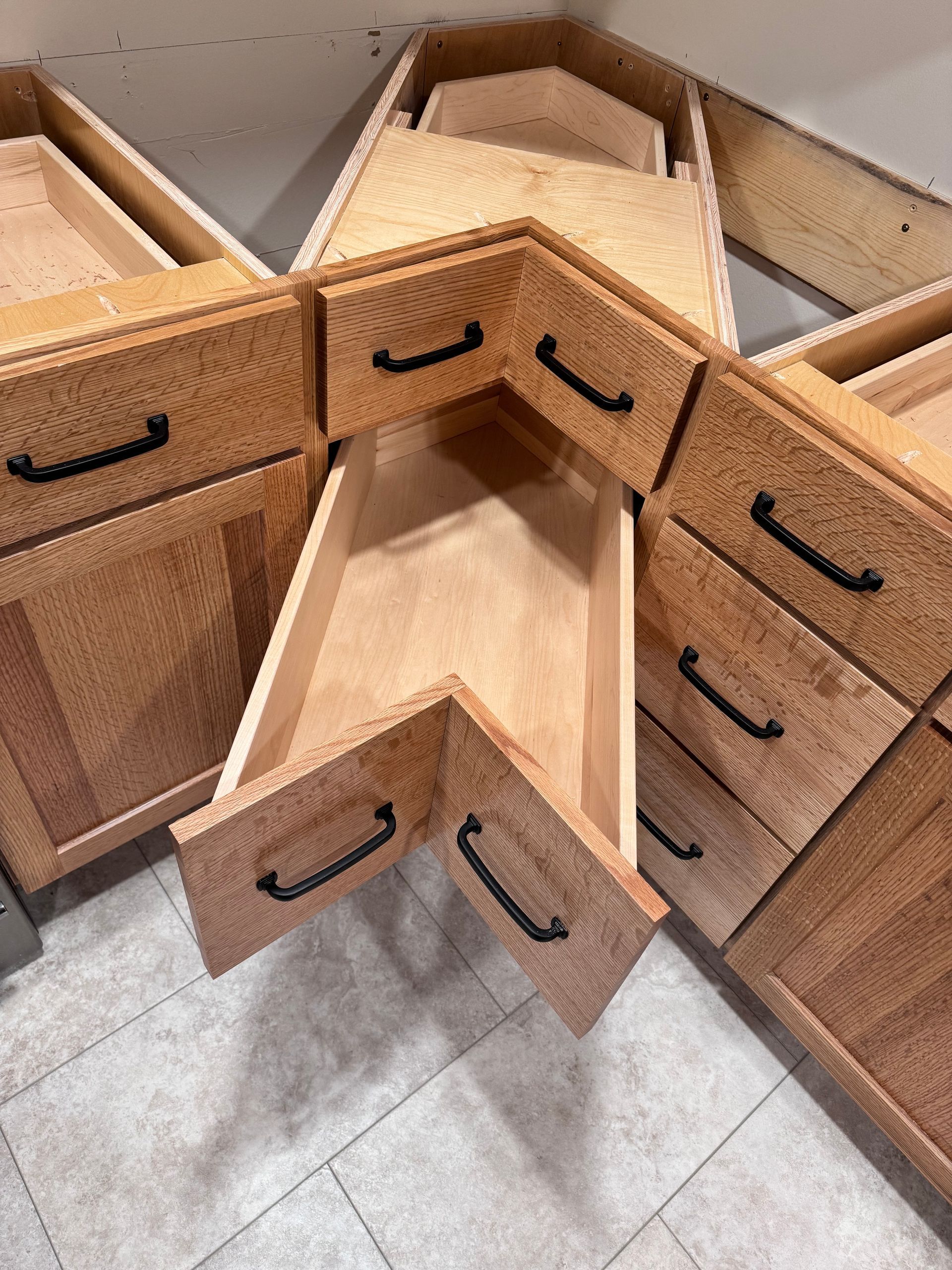 Wooden corner kitchen cabinets, one drawer open.