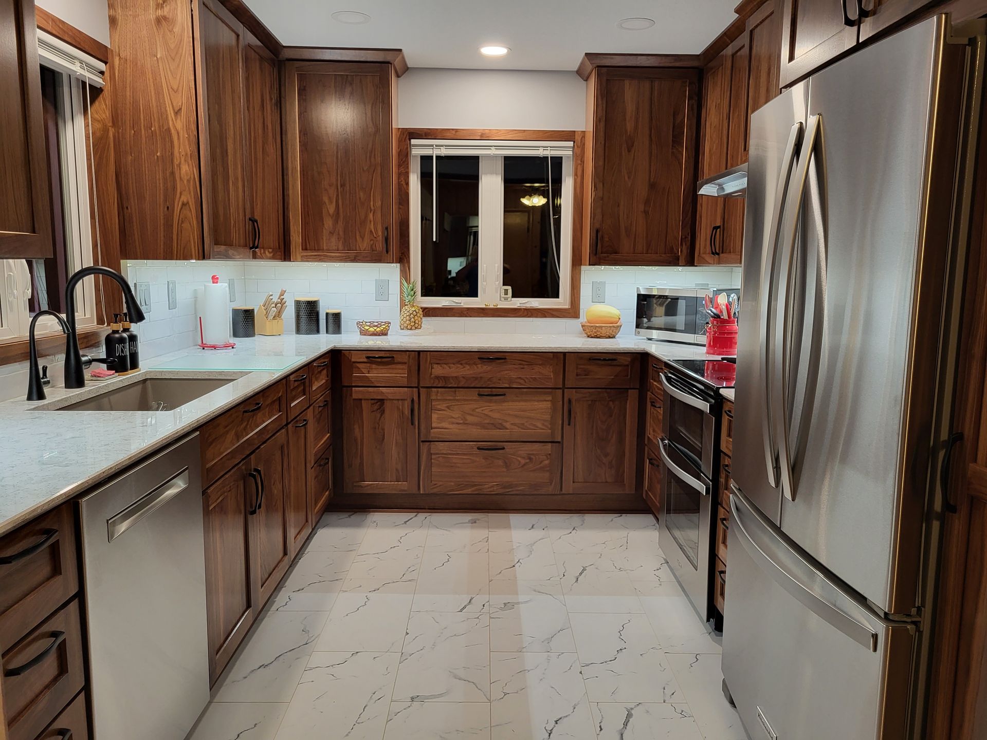 U-shaped kitchen with wood cabinets, stainless steel appliances, and a window over the countertop.