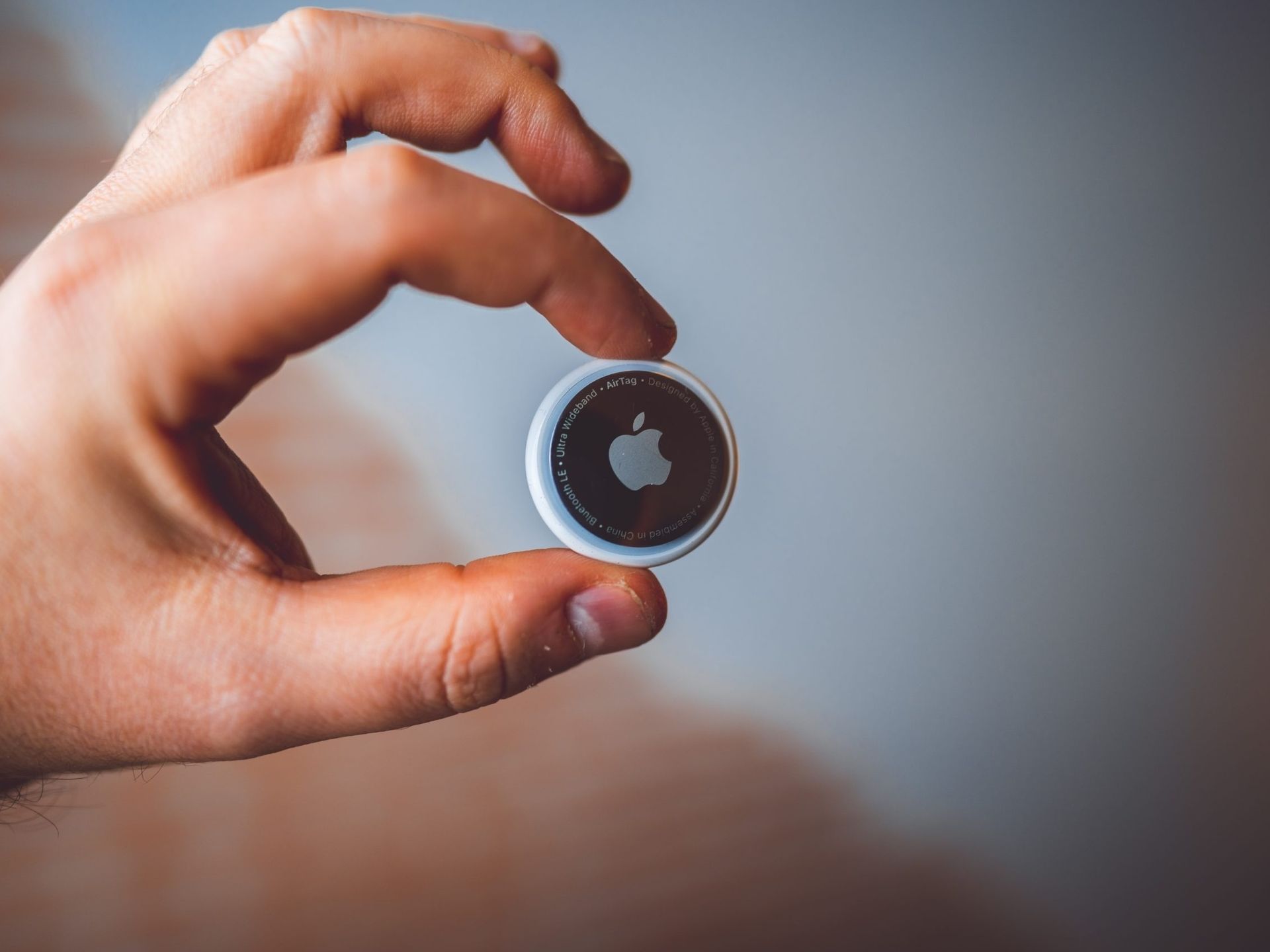 Uma pessoa está segurando um airtag de maçã na mão.