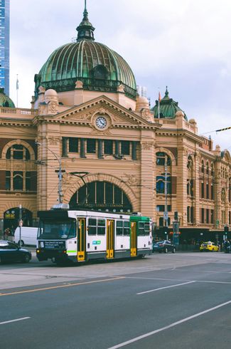 Um ônibus está estacionado em frente a um grande edifício