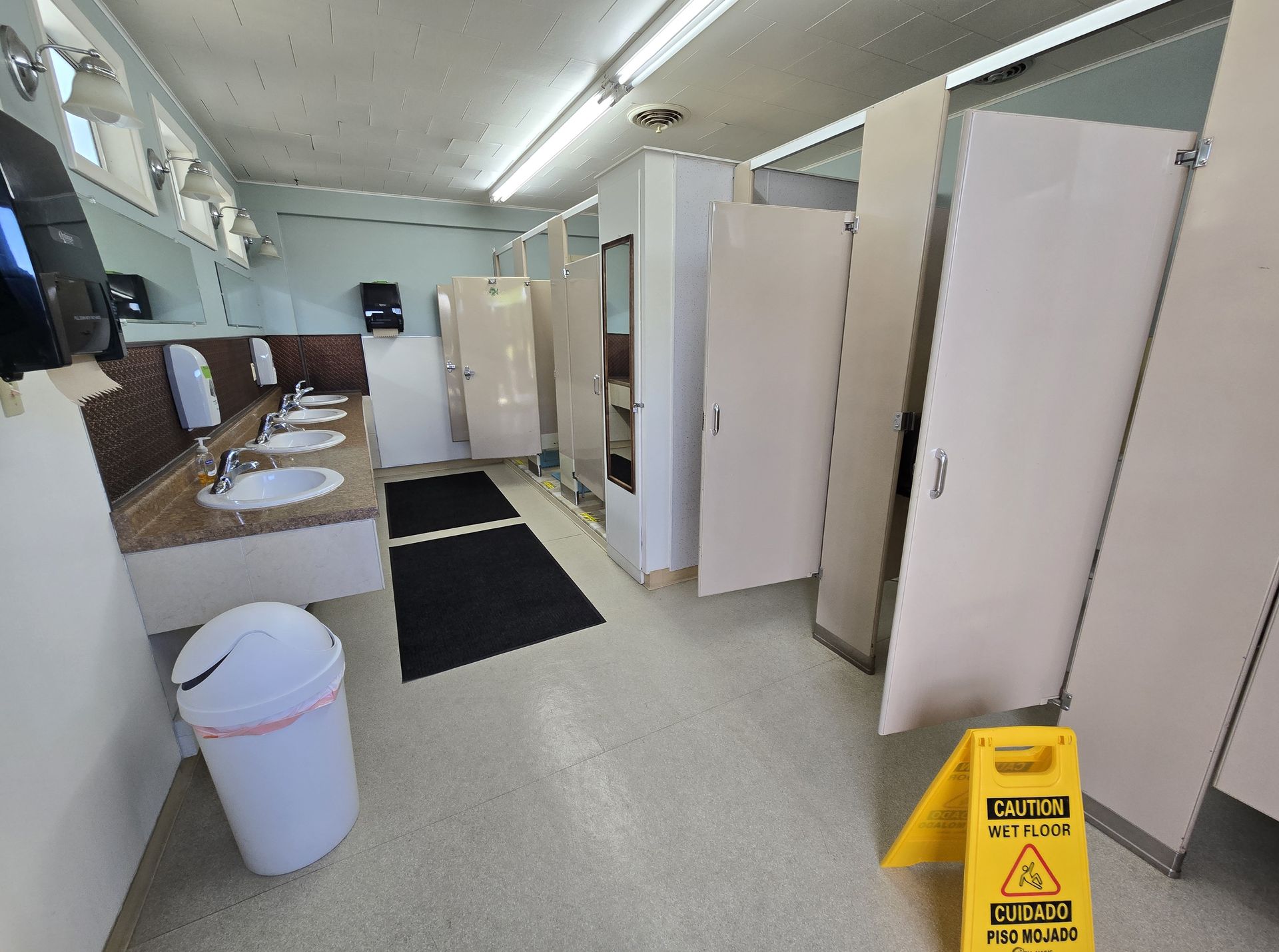 Public restroom with stalls, sinks, and a 