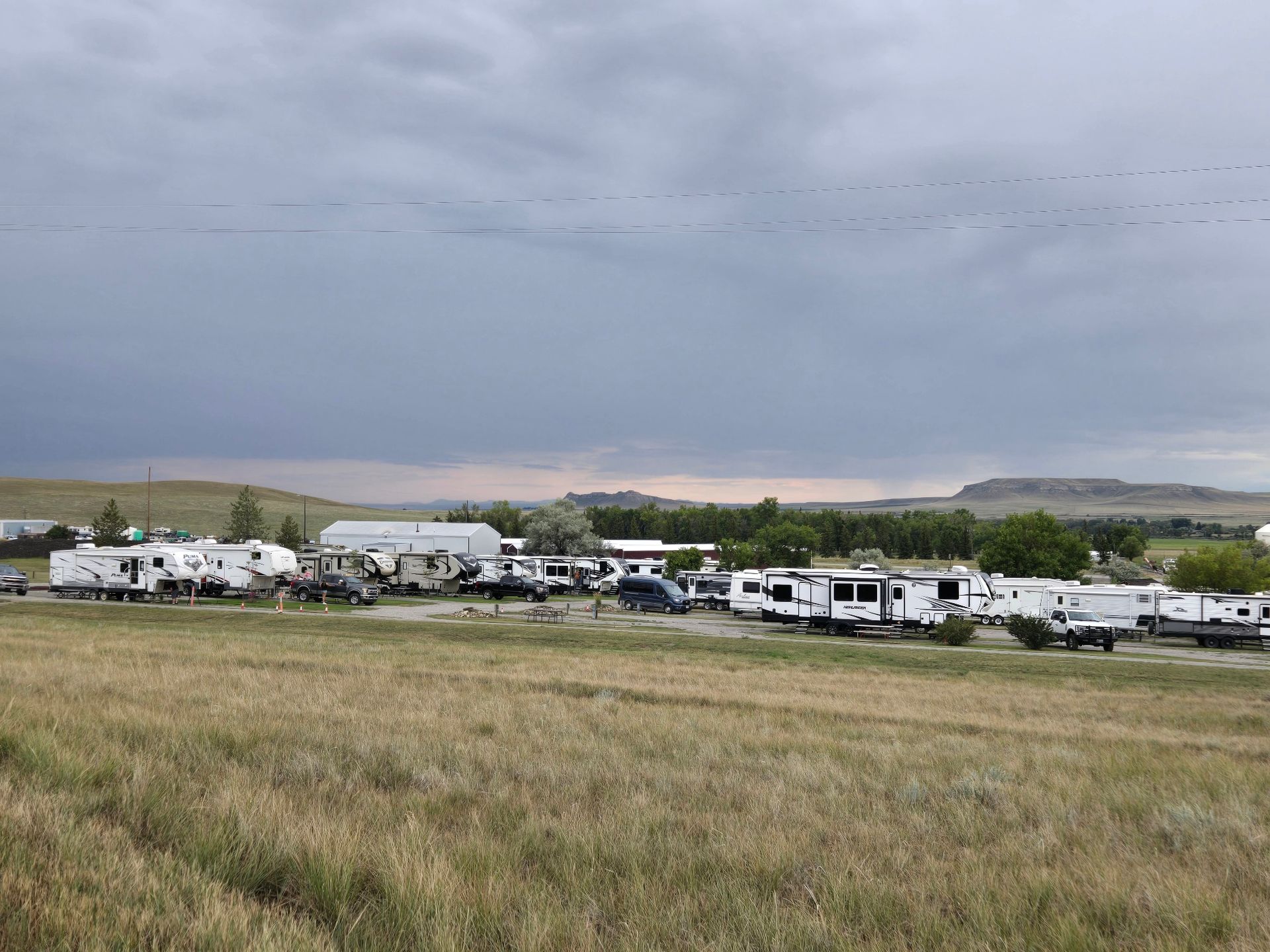 RV park in a field under a cloudy sky.