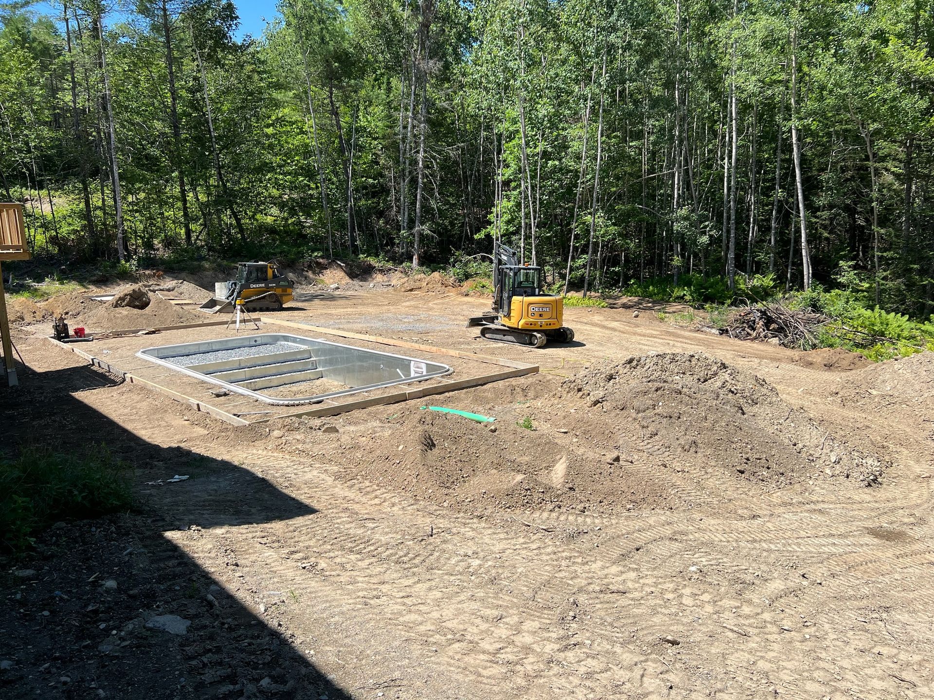 A construction site with a lot of dirt and trees in the background.