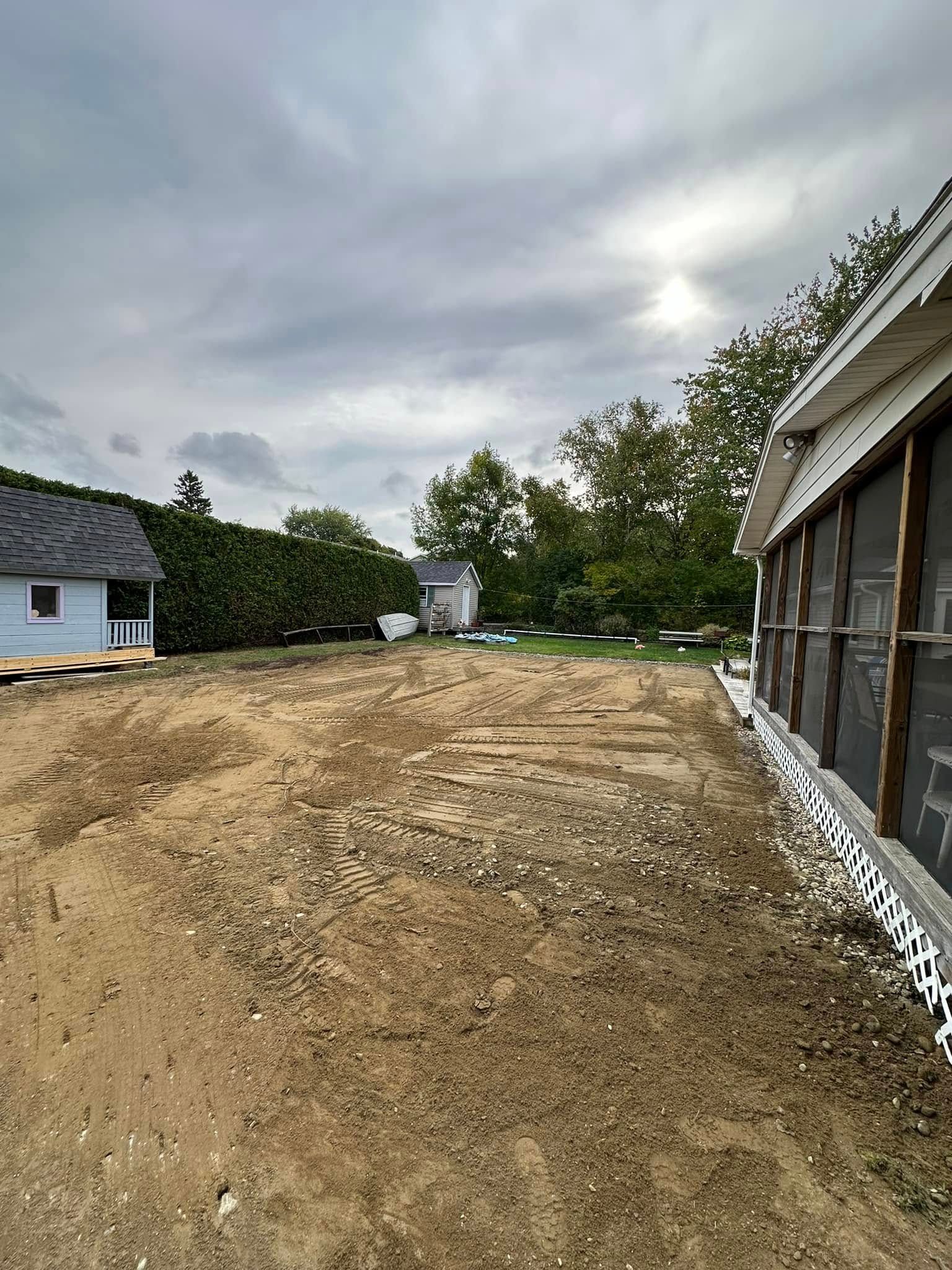 There is a house in the background and a lot of dirt in the foreground.