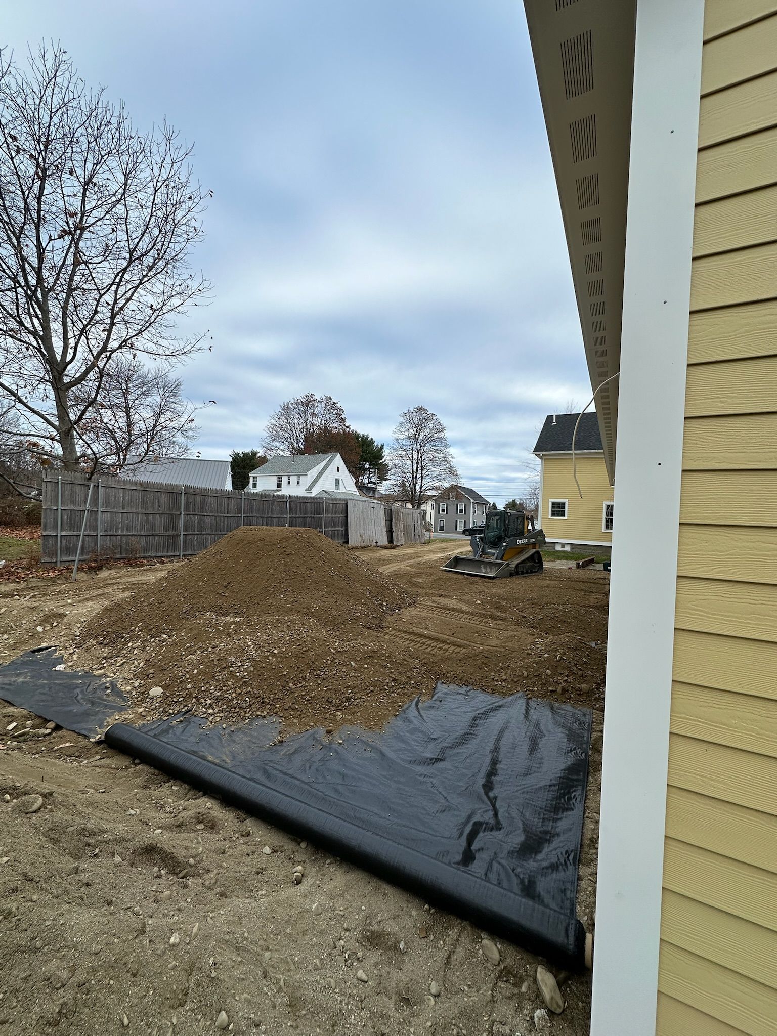 A large pile of dirt is sitting in front of a house.