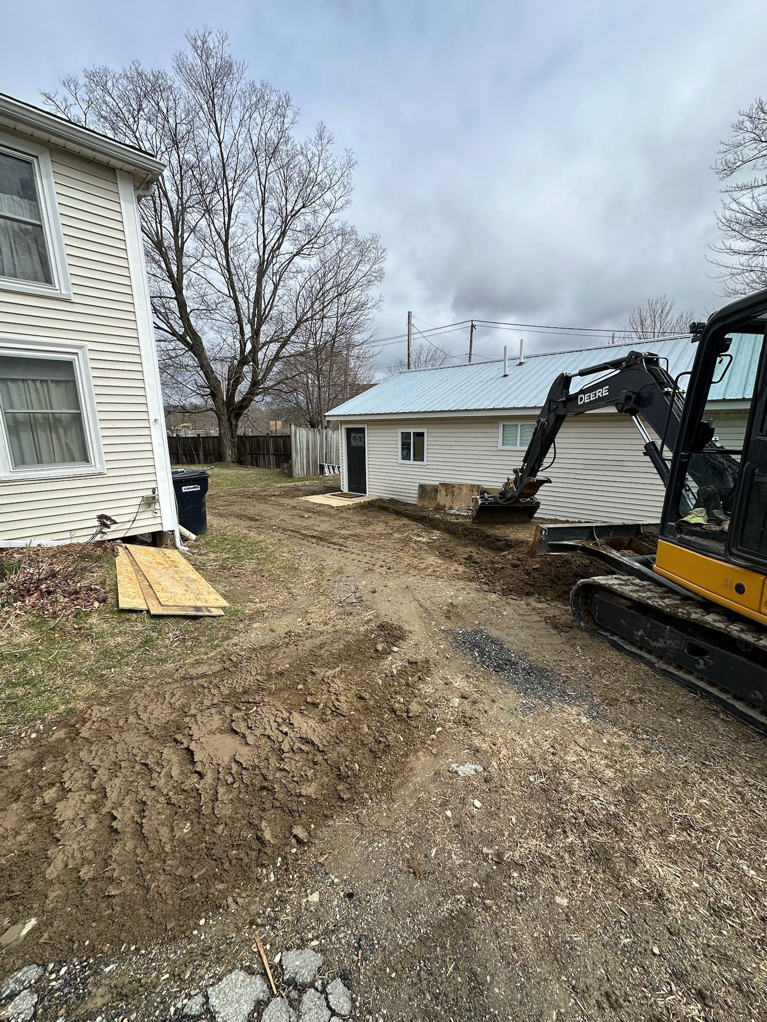 A bulldozer is moving dirt in front of a house.
