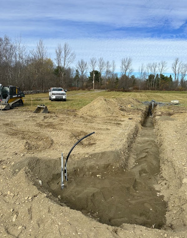 A bulldozer is digging a hole in the dirt in a field.