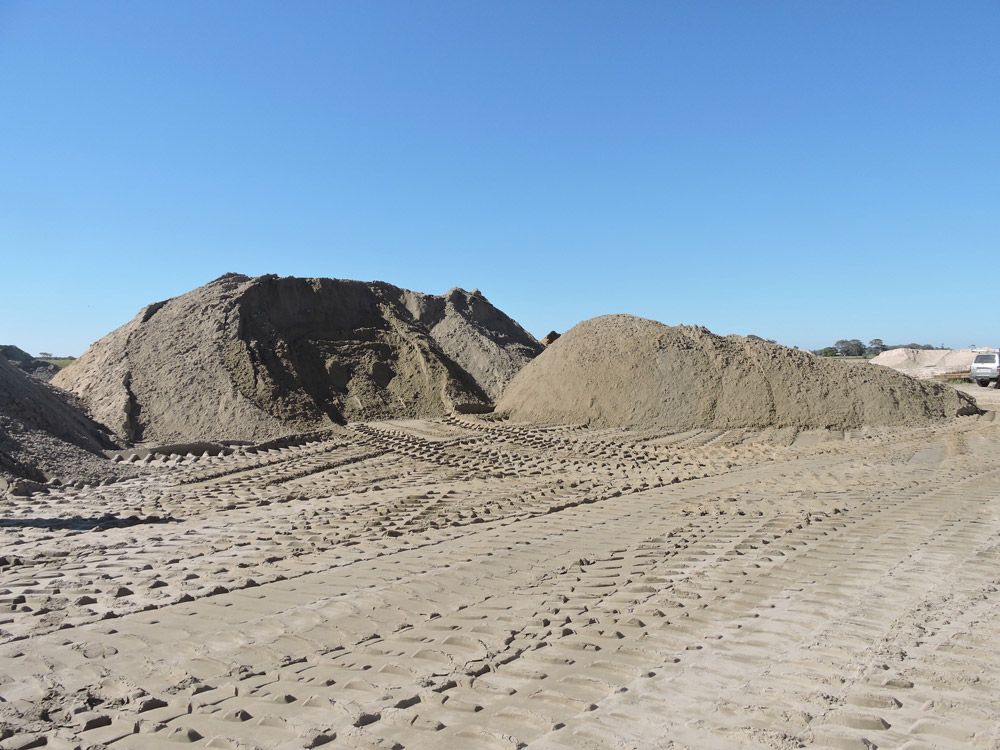 A pile of dirt is sitting in the middle of a dirt road