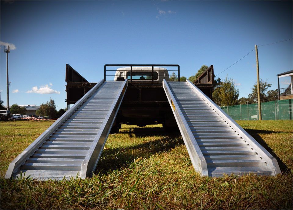 A truck is parked on a ramp in a grassy field