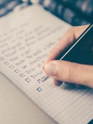 Person checking off list with pen in hand