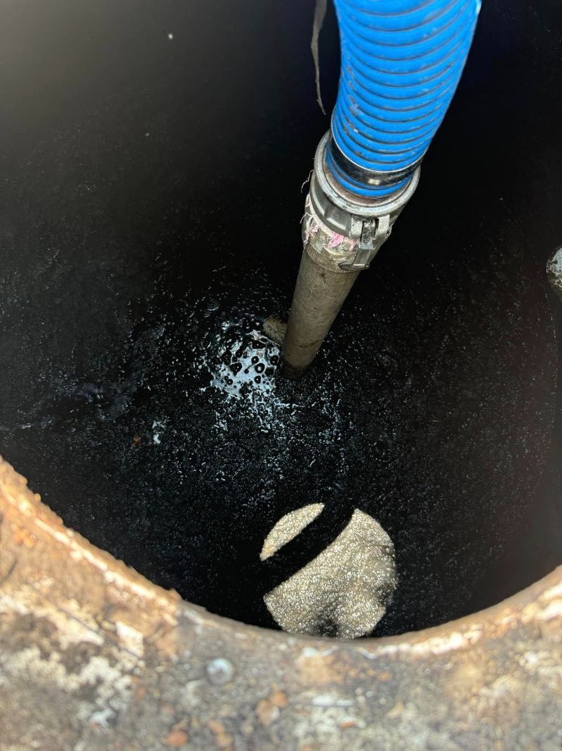 A Blue Hose is Being Used to Pump Water Into a Manhole — Ecotreat Solutions NT in Winnellie, NT