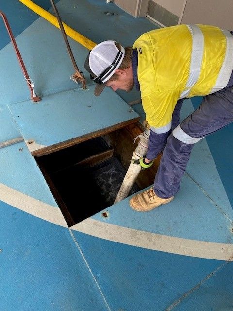 Man with Yellow Uniform Working Onsite Using Vacuum — Portable Toilets in Winnellie, NT