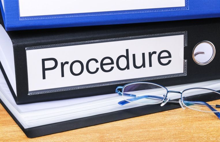 Man holding a megaphone, covering his ear with other hand, reacting to loud sound.