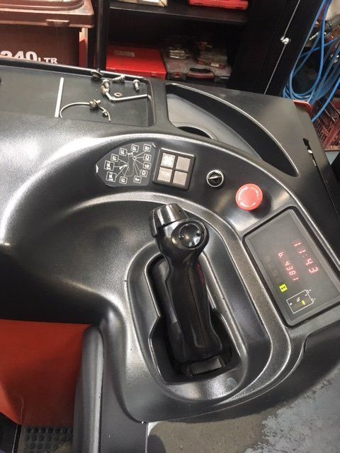 A close up of a steering wheel with a red button on it