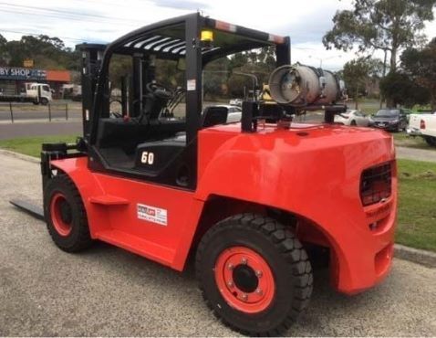 A red forklift is parked on the side of the road - heavy lift forklifts melbourne