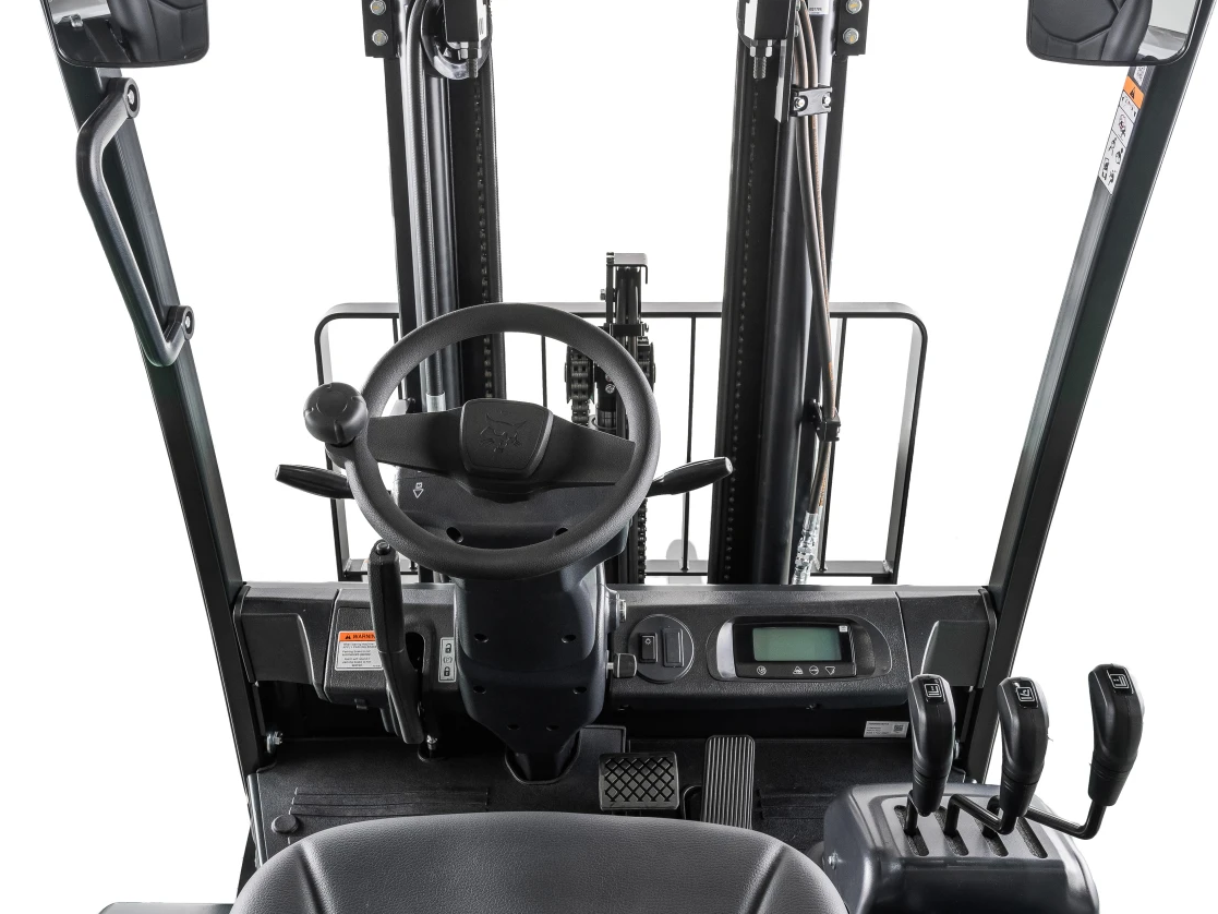 Forklift interior, steering wheel, digital display, control levers.