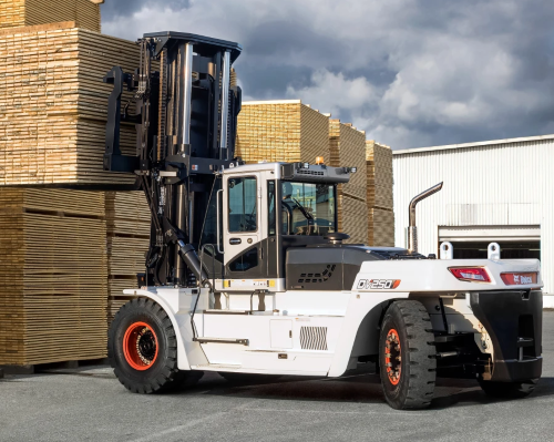 Large white forklift lifting lumber outside a warehouse.