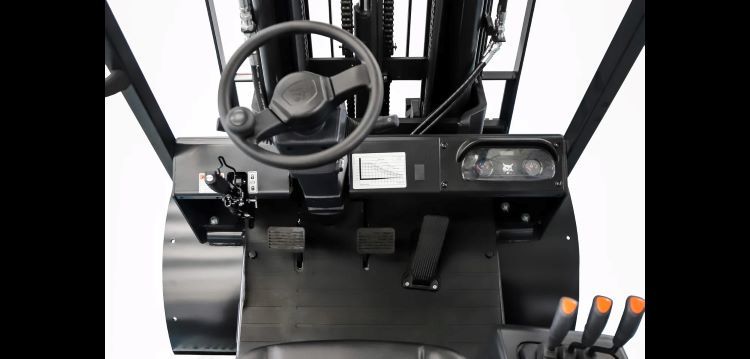 The inside of a bobcat forklift with a steering wheel and controls.
