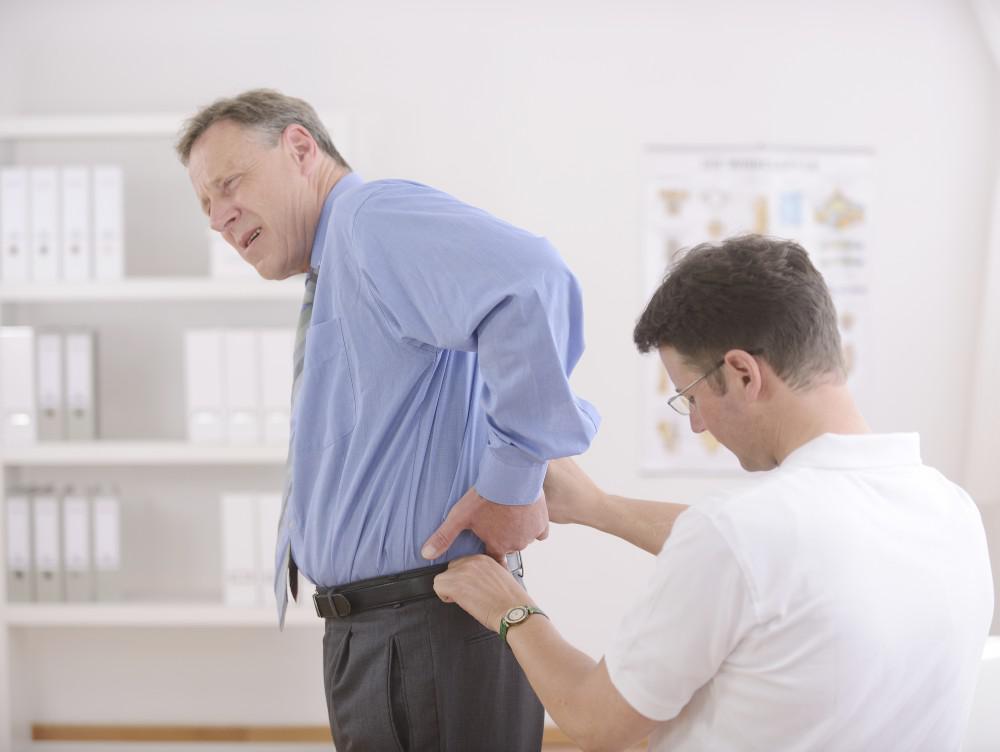 Therapist Checking Man's Back Pain — Cheyenne, WY — Northview Medical