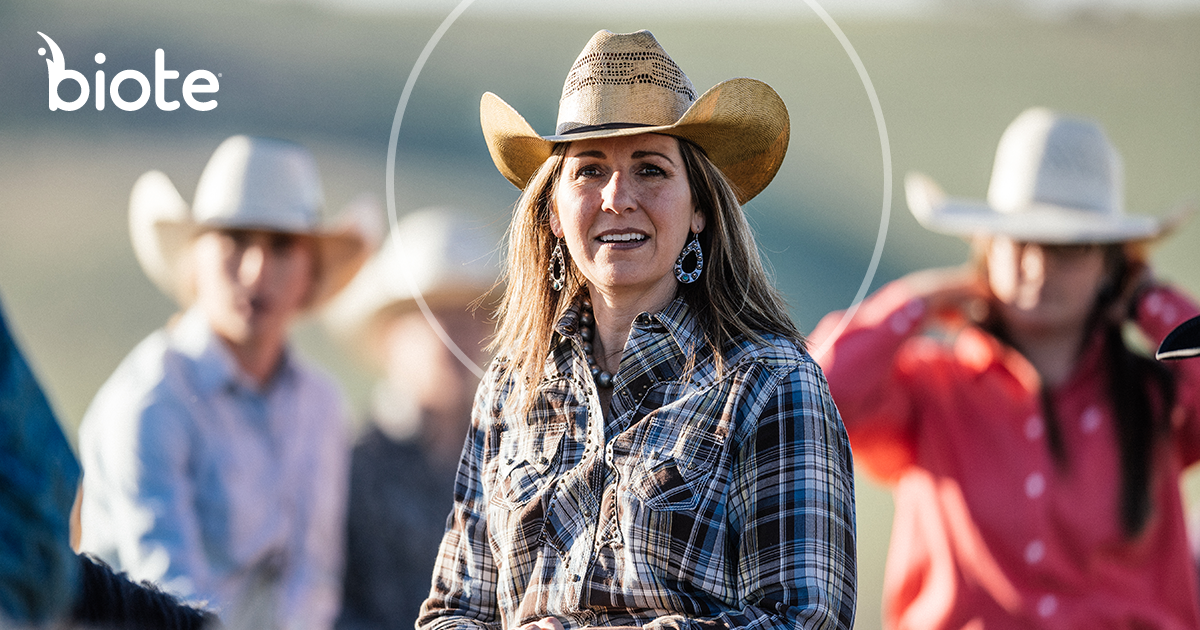 A woman in a cowboy hat is standing in front of a group of people wearing cowboy hats.