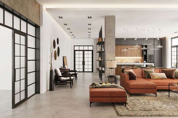 Soggiorno moderno con divano componibile color ruggine, cucina sullo sfondo, porte con cornice nera e pavimento in cemento.