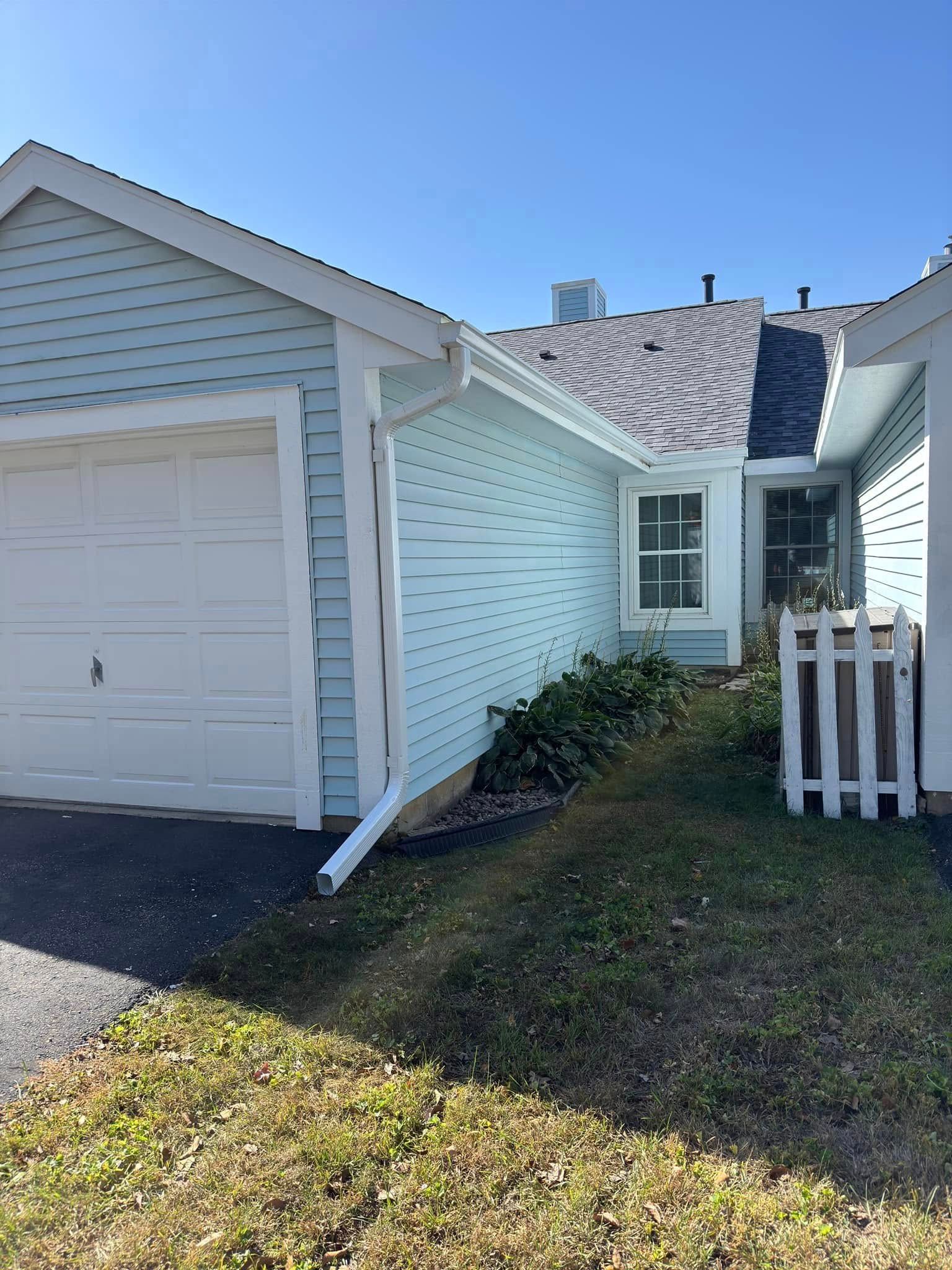 Blue house with garage and a small yard.