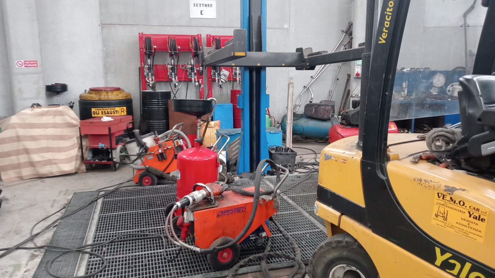Un carrello elevatore giallo è parcheggiato su un elevatore in un garage.