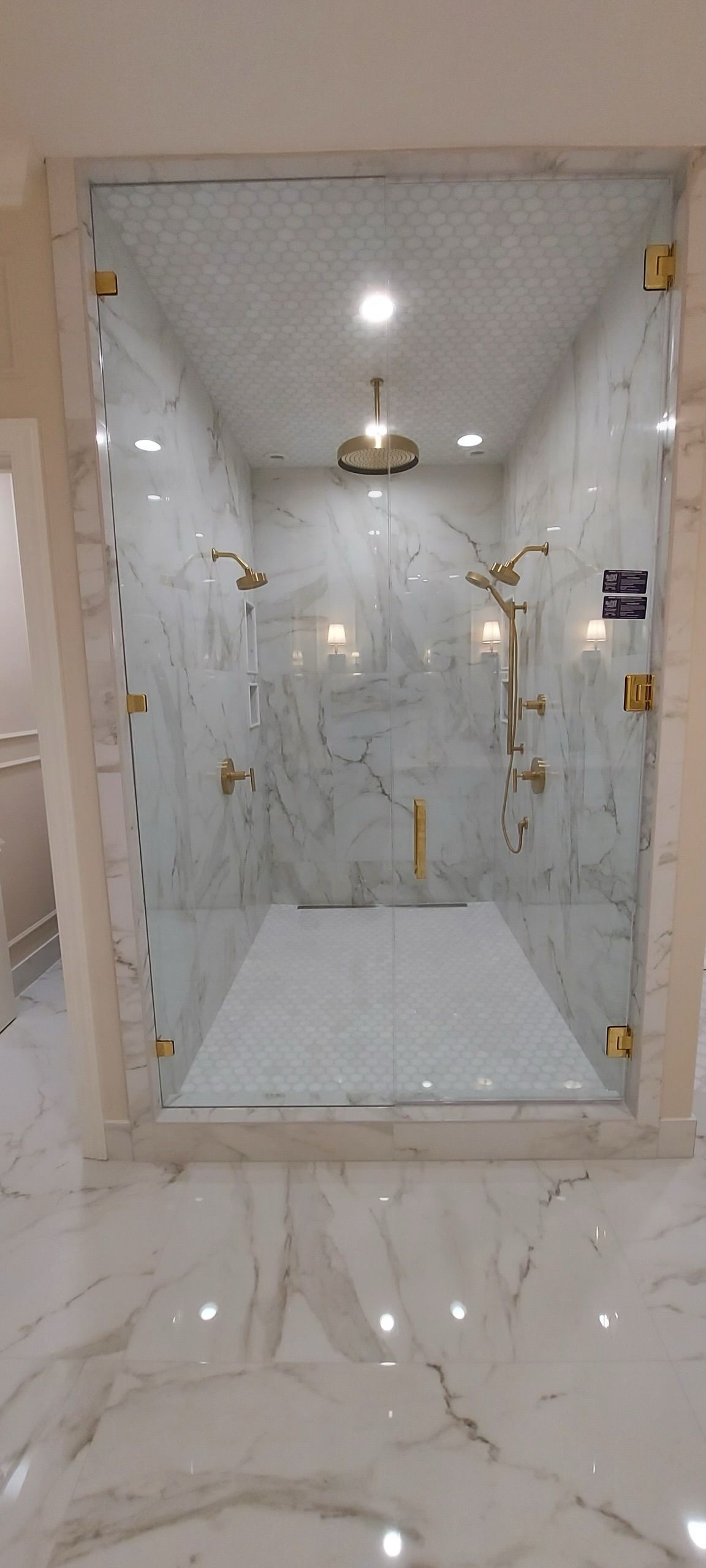 A bathroom with a walk in shower and a marble floor.