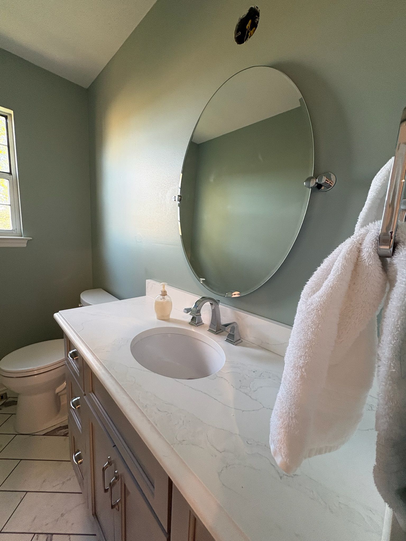 A bathroom with a sink , toilet , and mirror.