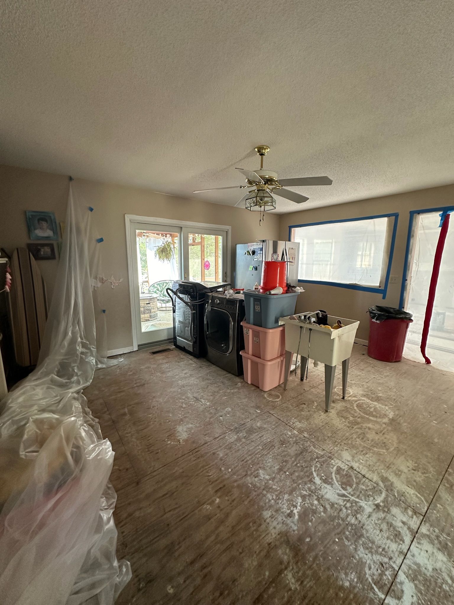 A room with a ceiling fan and a sink in it.