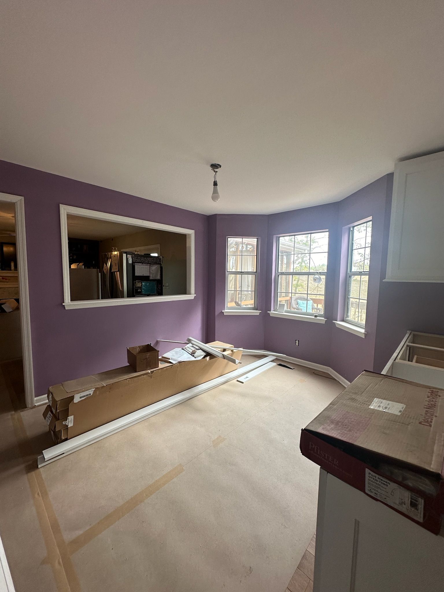 A living room with purple walls and a large window.