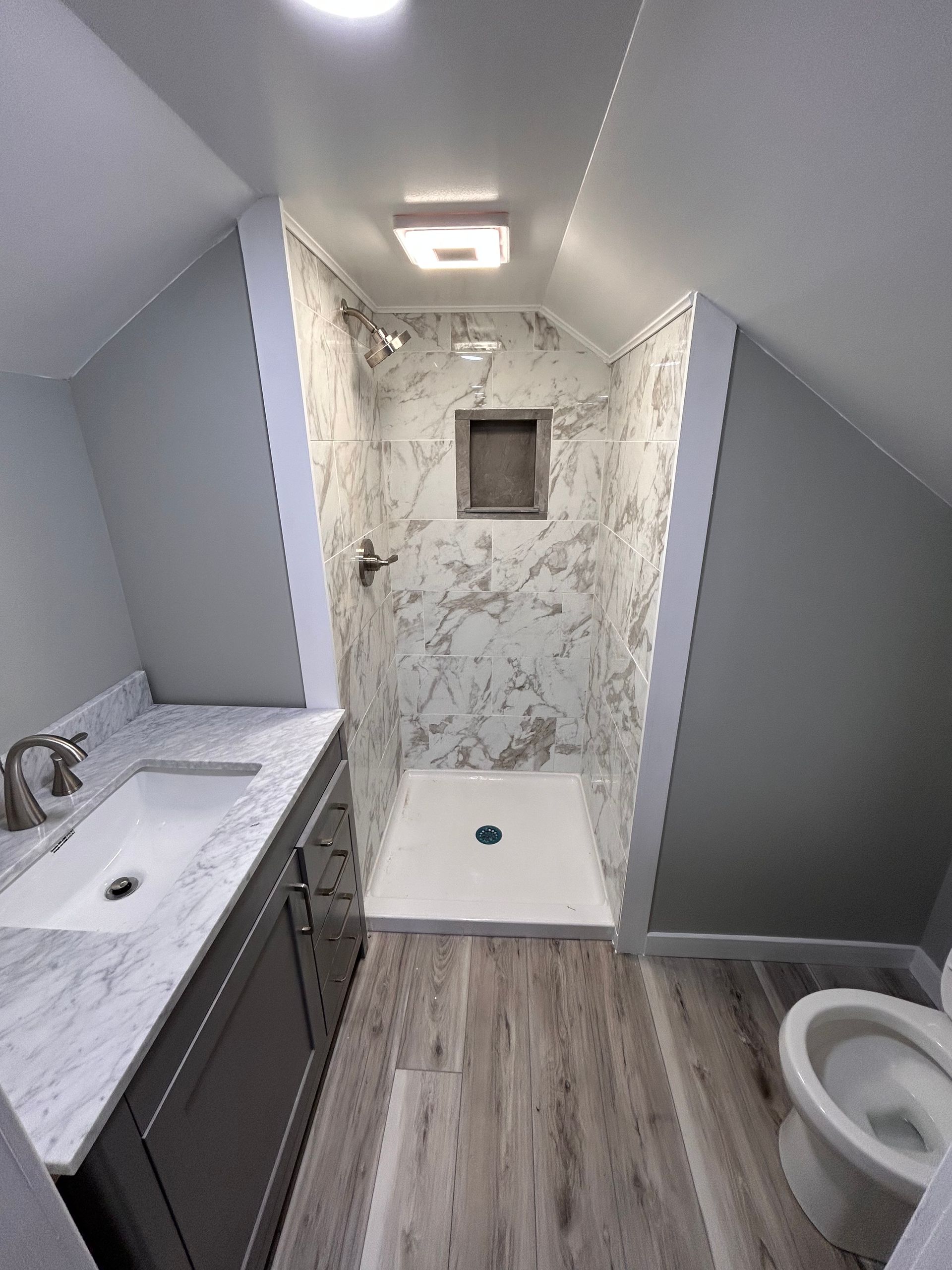 A bathroom with a sink , toilet and shower.