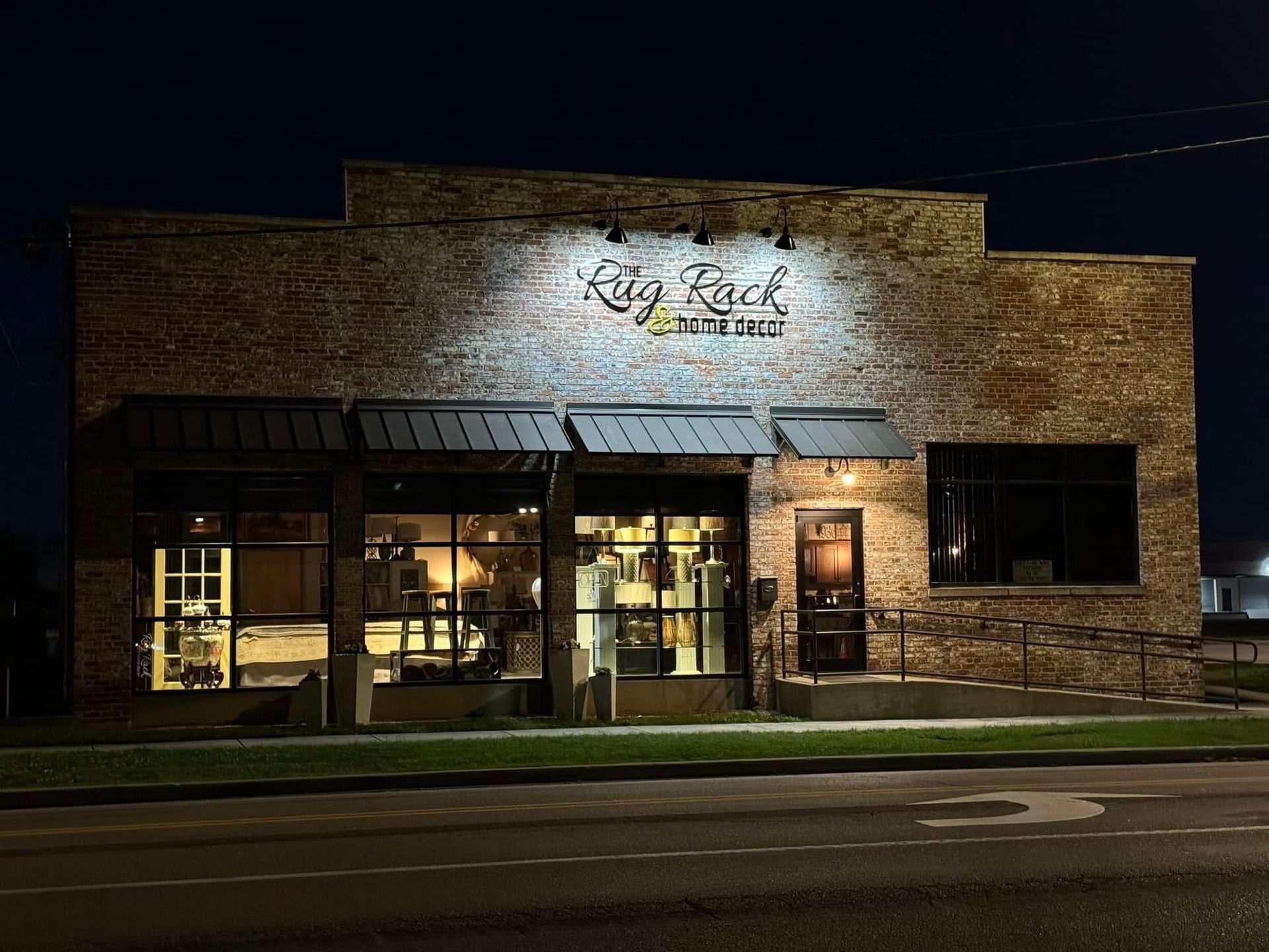 A large brick building with a lot of windows is lit up at night.