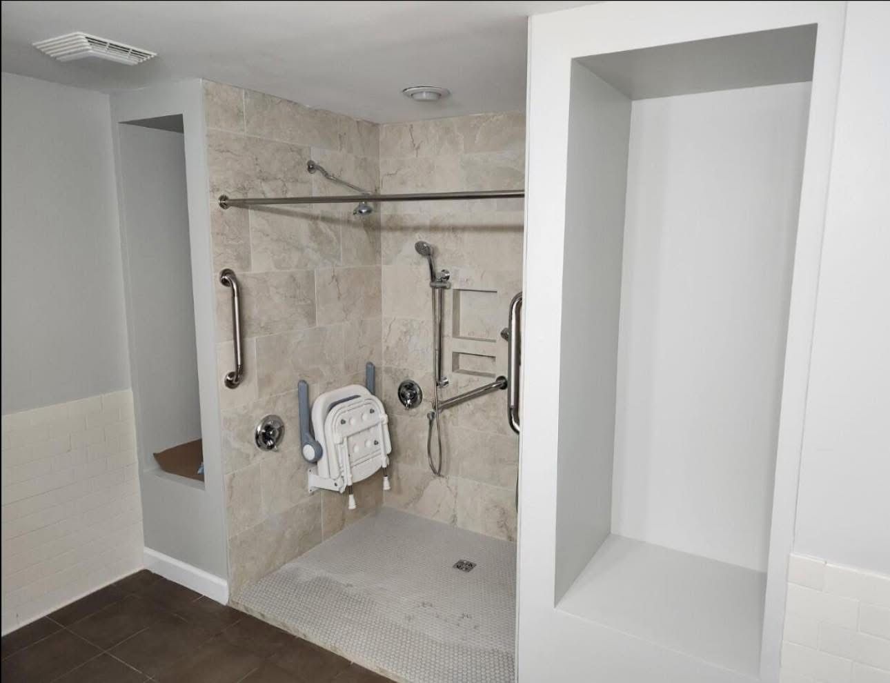 A bathroom with a walk in shower and a handicap seat.