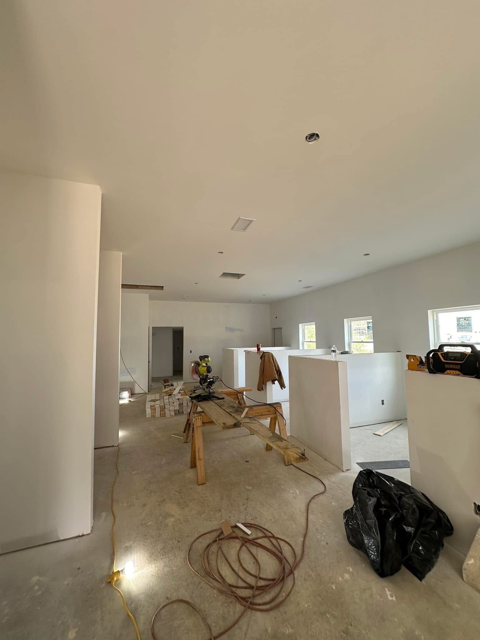 A large room with a lot of white walls is being remodeled.