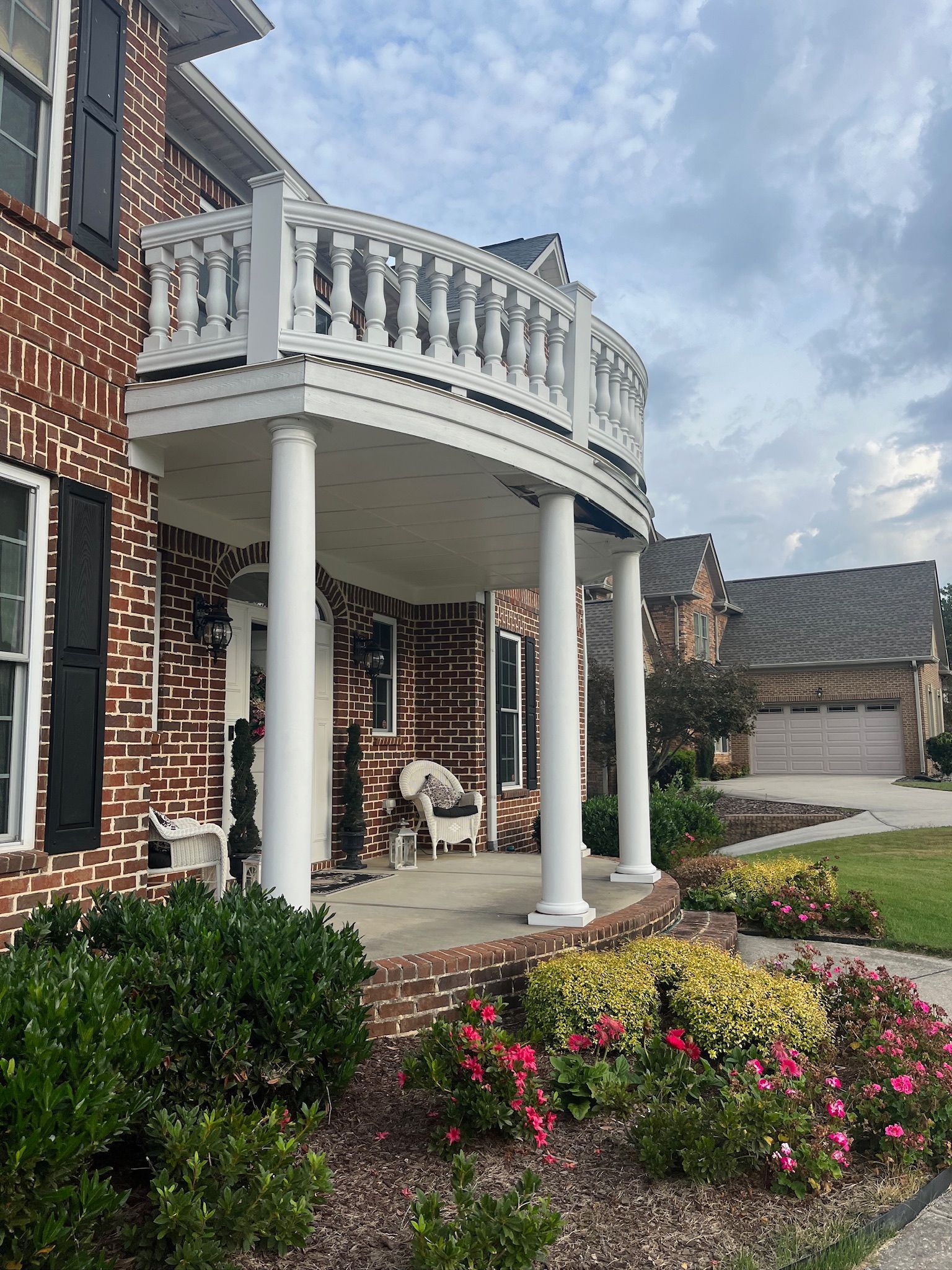 A large brick house with a balcony and columns