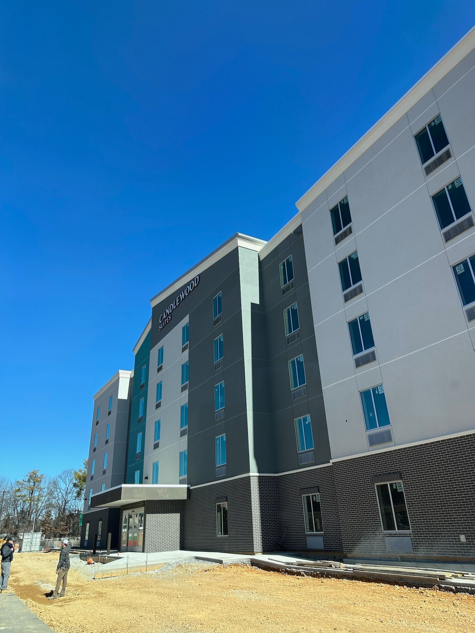 A large building with a lot of windows and a blue sky in the background.