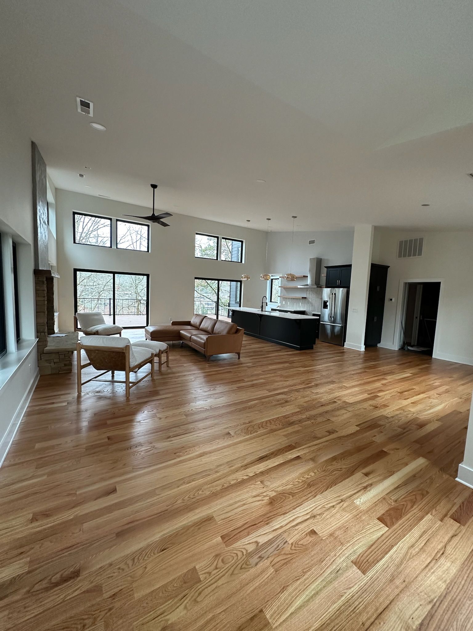 A large living room with hardwood floors and a ceiling fan.