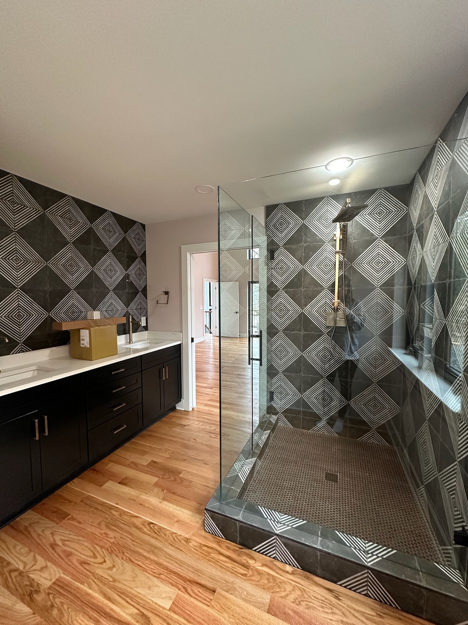 A bathroom with a walk in shower and a sink.