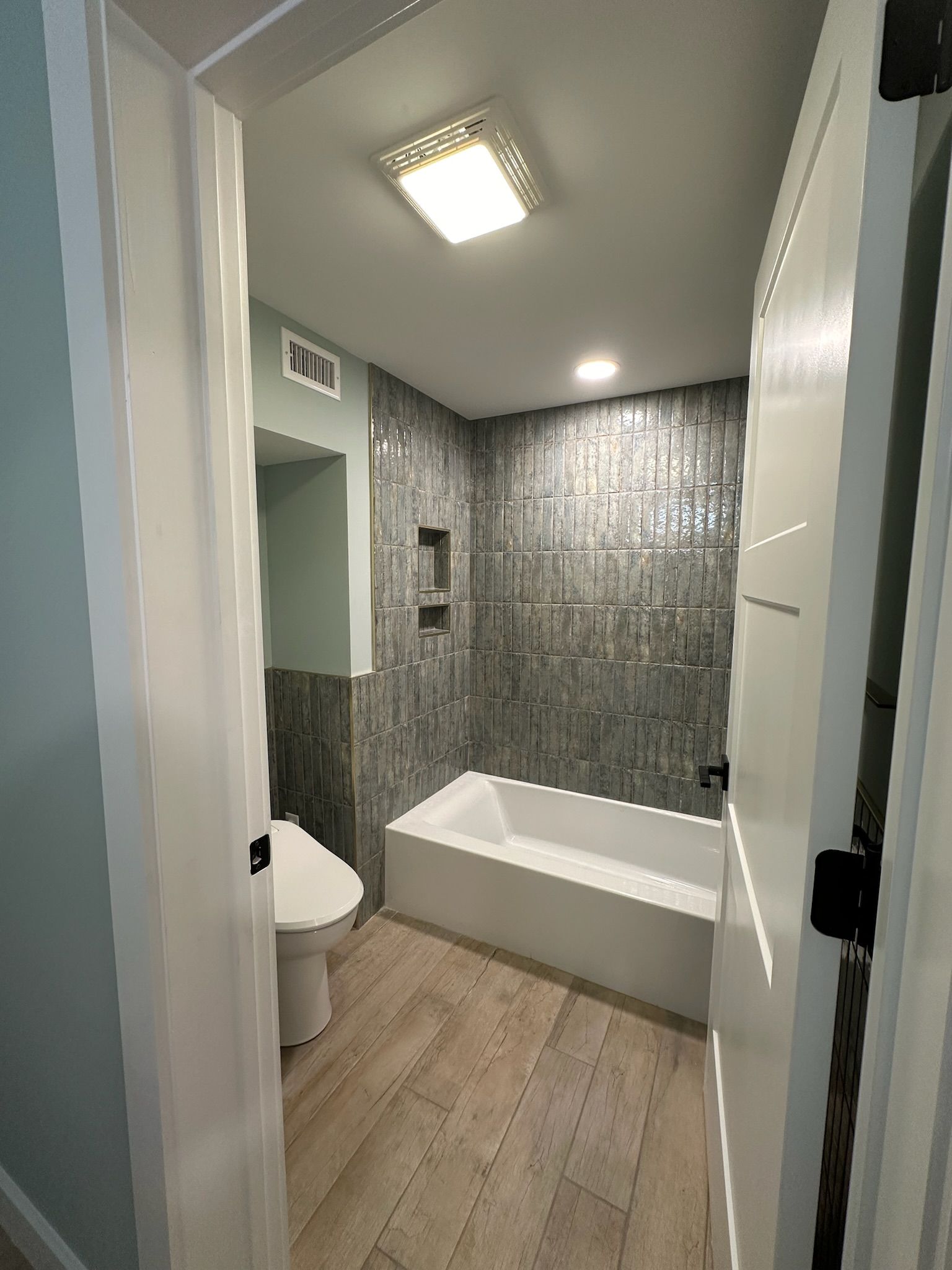 A bathroom with a tub , toilet and shower.