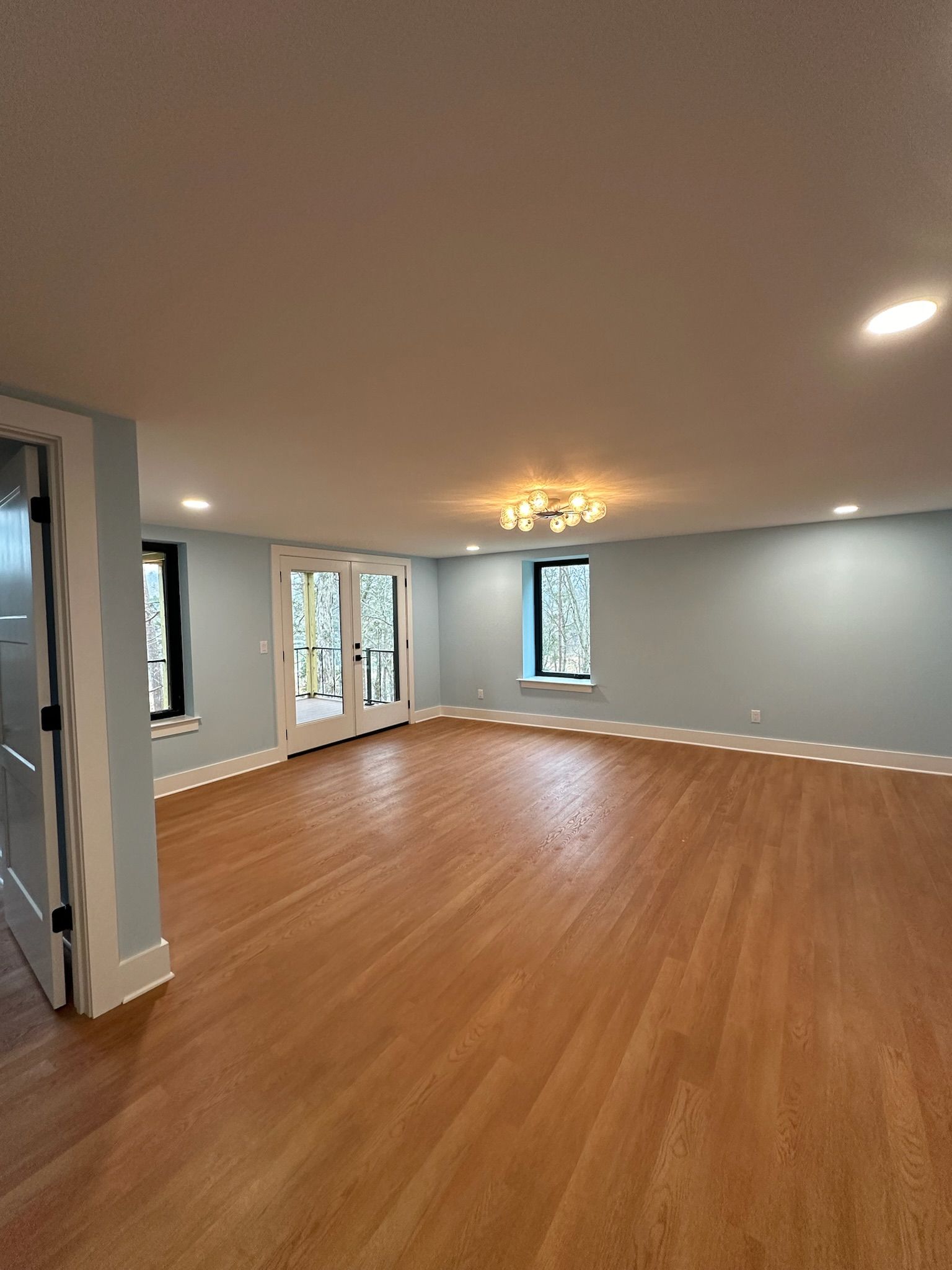 A large empty room with hardwood floors and blue walls.